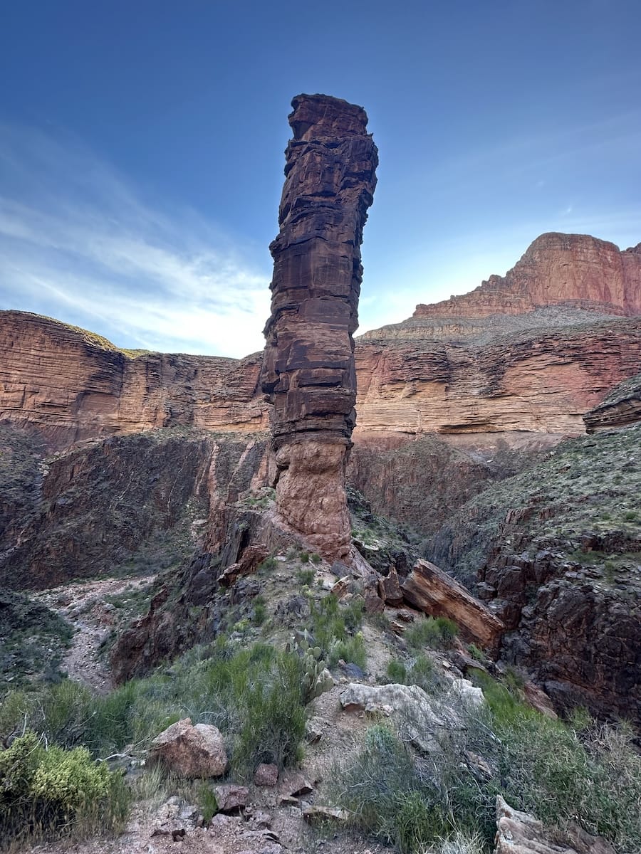 grand-canyon-monument-rock-formation-view Monument-like rock formation in the Grand Canyon with layered canyon walls and a blue sky.