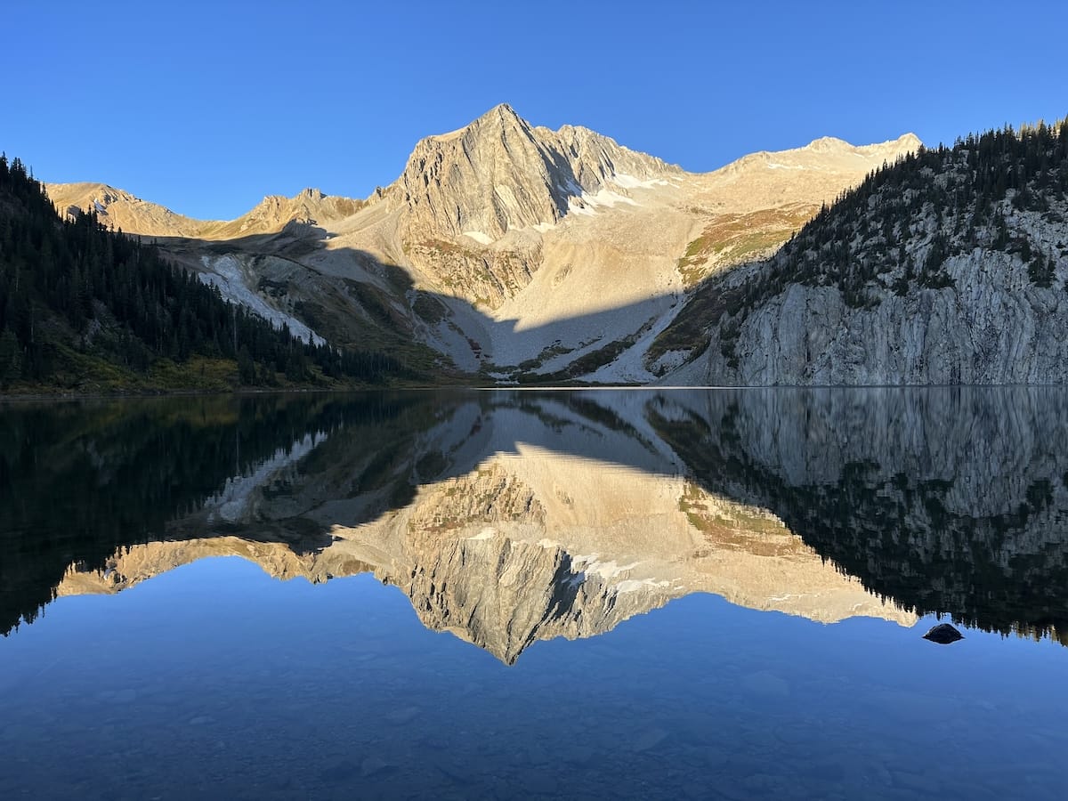 Snowmass Lake with mountain reflection in morning light.