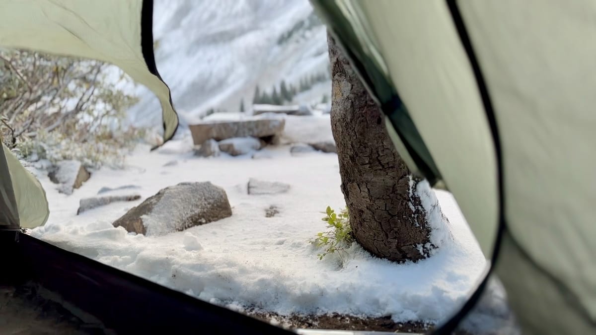 View from inside a tent at a snowy campsite on Capitol Peak Trail.