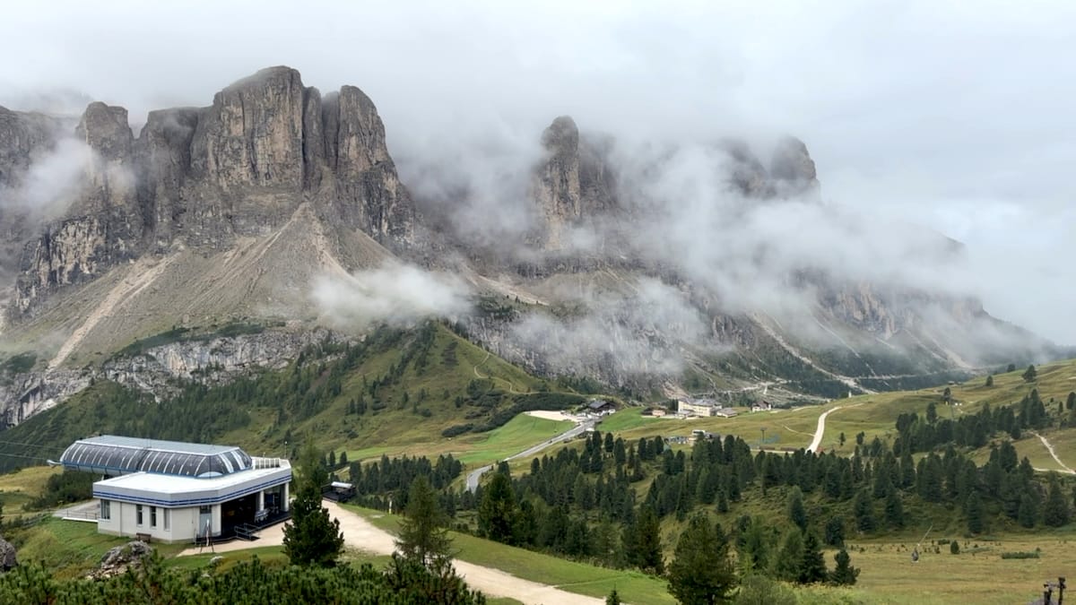 Mountain peaks and gondola station at Passo Gardena on the Alta Via 2 with clouds.