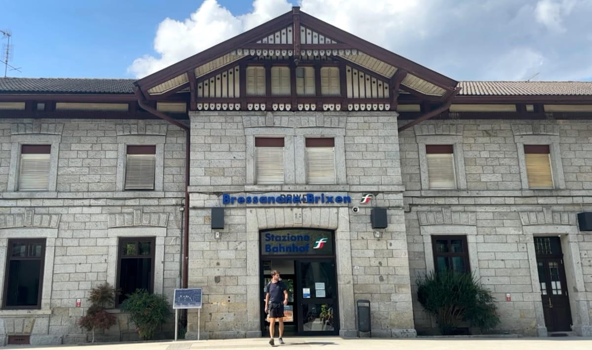 Bressanone-Brixen train station building, starting point for Alta Via 2, with hiker exiting.