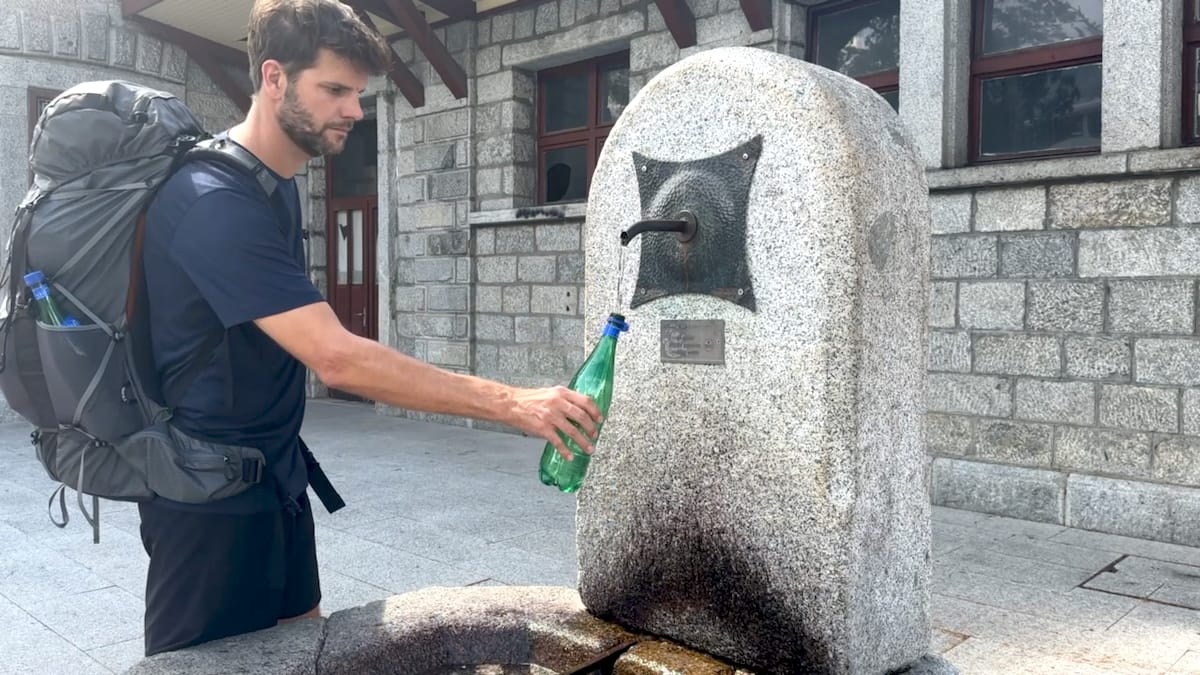 Alta Via 2 hiker refilling bottle at Bressanone train station.