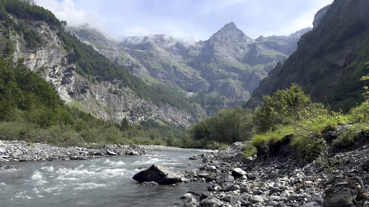 River flowing through rocky valley while Hiking the Cirque du Fer-à-Cheval in August.