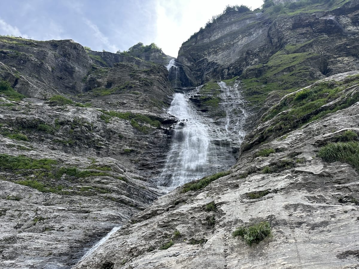 Tall waterfall cascading down a rocky cliff in Cirque du Fer-à-Cheval.