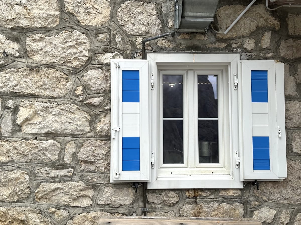 Blue shutters on a stone wall at Rifugio Mulaz.