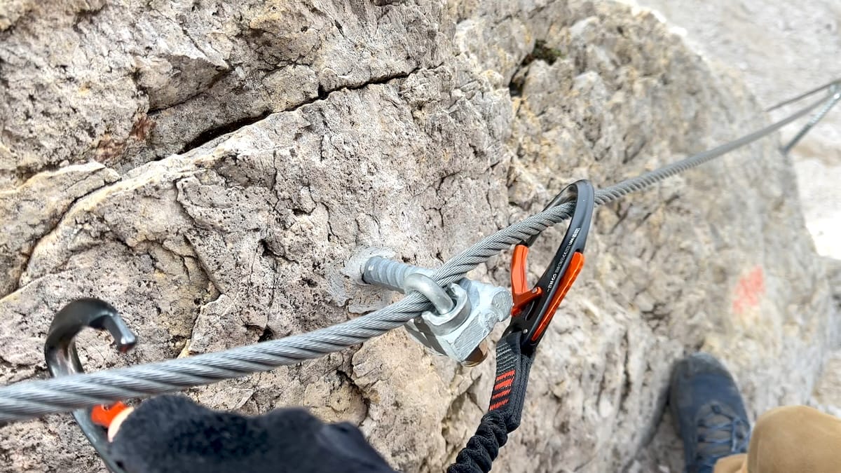 Close-up of via ferrata cable and carabiner during a climb towards Passo delle Farangole.