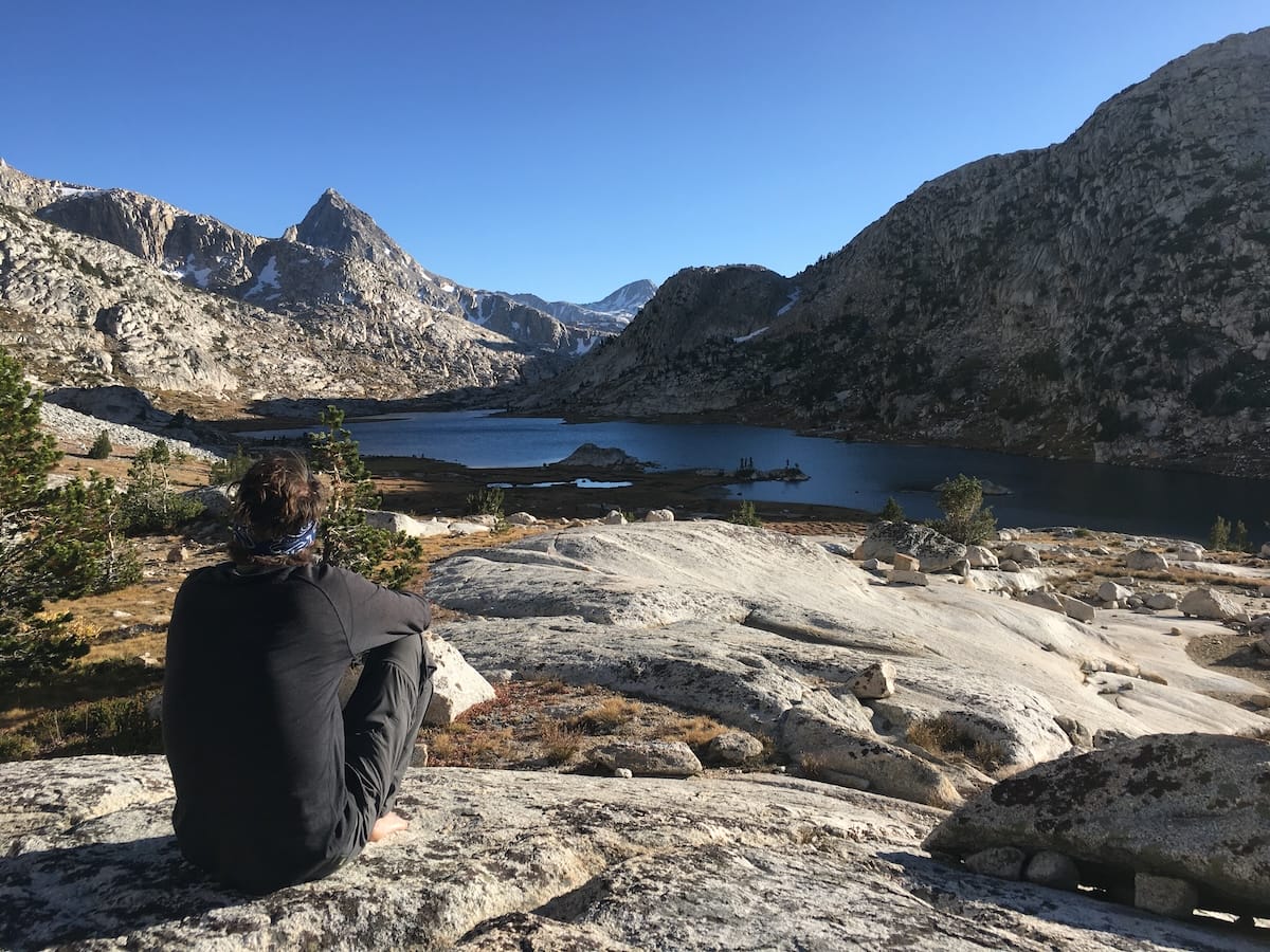 Hiker enjoying the view of Evolution Lake wearing Smartwool Merino Base Layer.
