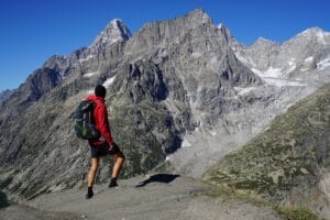 osprey-exos-48-mount-blanc Hiker wearing Osprey Exos backpack and red rain jacket at a look out of Mont Blanc.