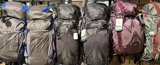 A store display of Osprey backpacks on a wall.