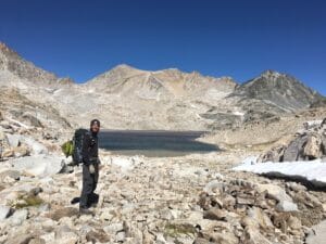 PCT hiker in the Sierra Nevada wearing cold weather backpacking gear.