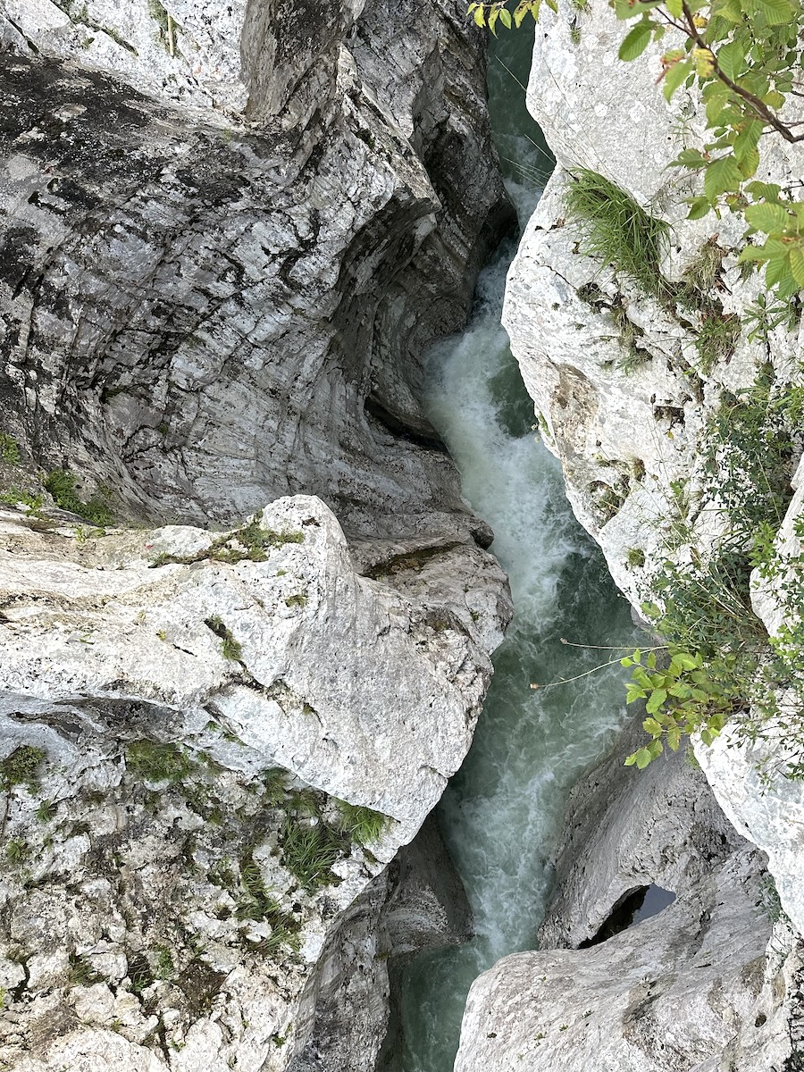 Looking straight down into a deep narrow chasm with the Soča River rushing below