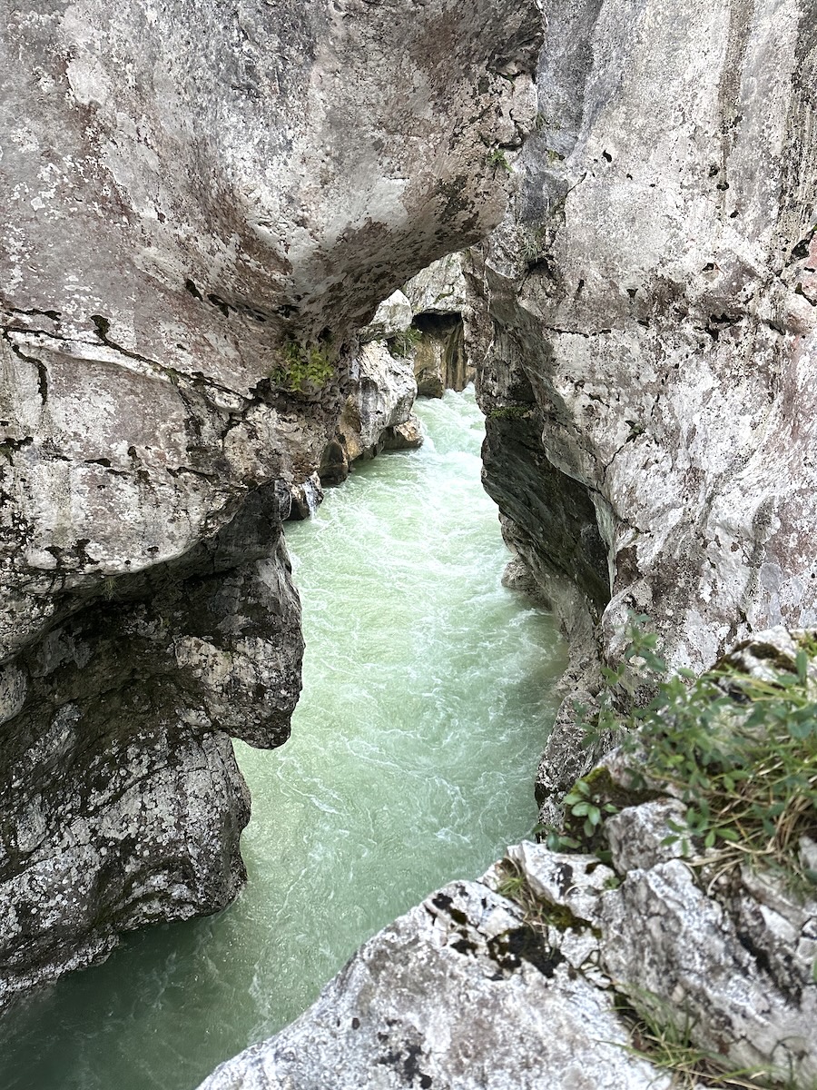 Natural rock bridge spanning over the emerald Soča River in a deep gorge