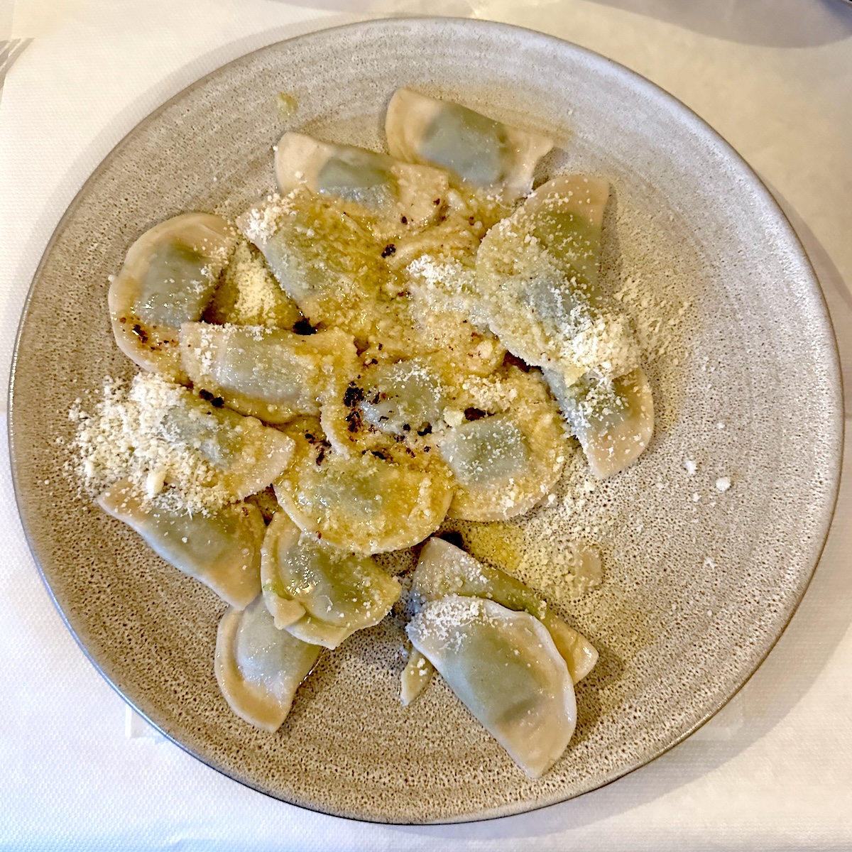 Traditional spinach ravioli (Schlutzkrapfen) with butter and cheese