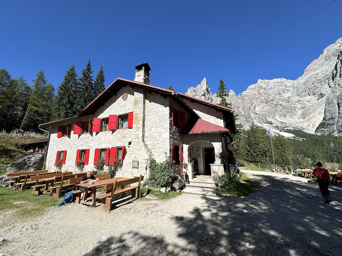 Stone hut Rifugio Vazzoler with red shutters