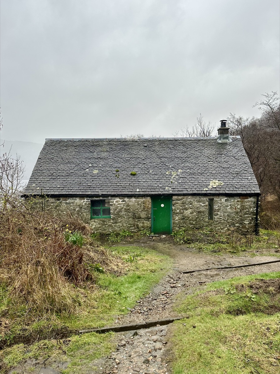 Exterior of Doune Bothy on the east shore of Loch Lomond on the West Highland Way with green door