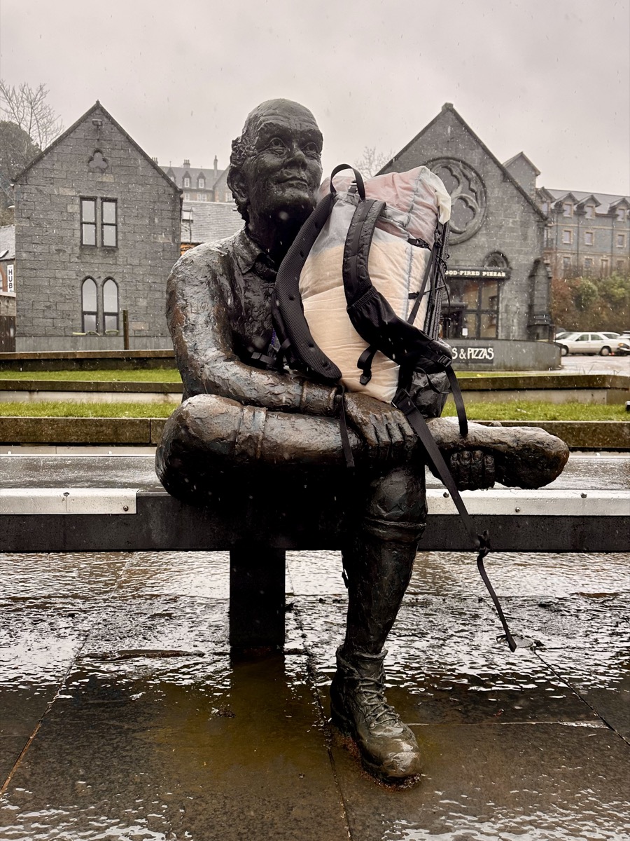 Hiker's pack placed on the West Highland Way finish statue in Fort William in the snow