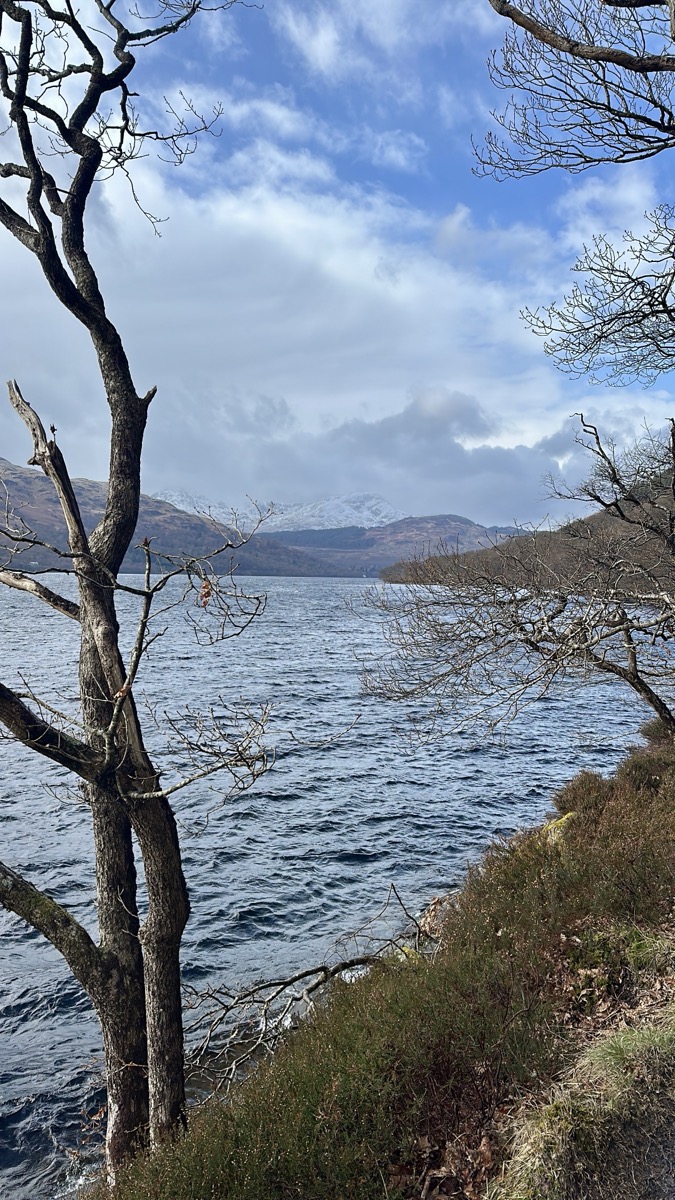 Loch Lomond looking north toward snow-capped mountains from the east shore on the West Highland Way