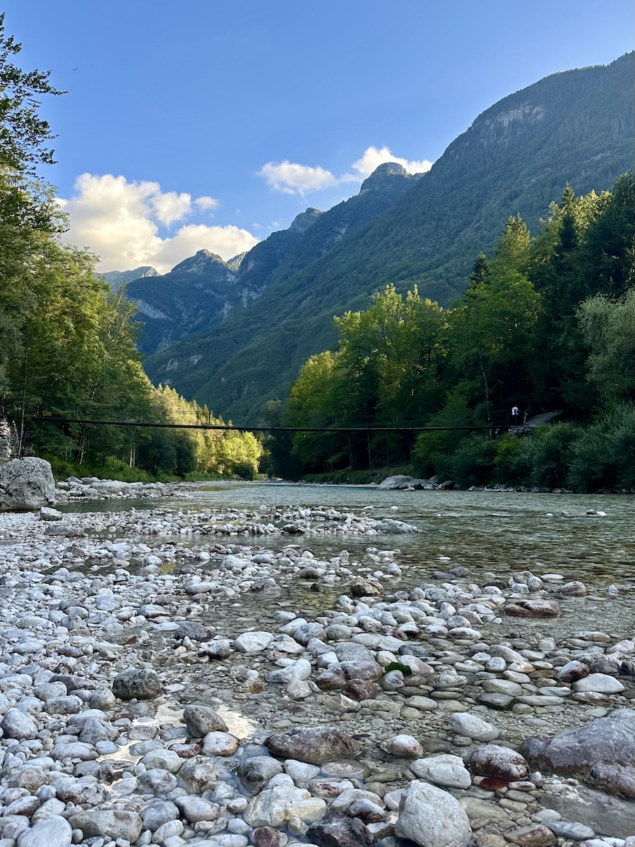 soca-river-suspension-bridge-triglav-national-park A suspension bridge crossing the Soča River below Velika Korita, with white cobbles in the riverbed.